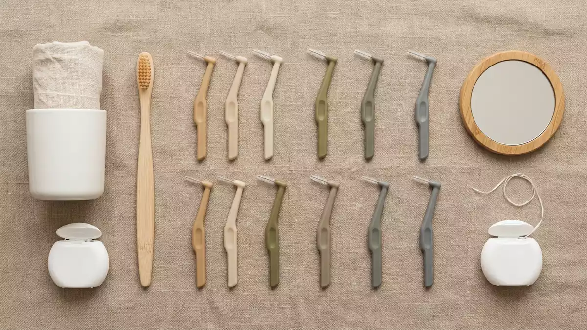 Flatlay-Arrangement rund um Interdentalbuersten mit passenden Requisiten von oben