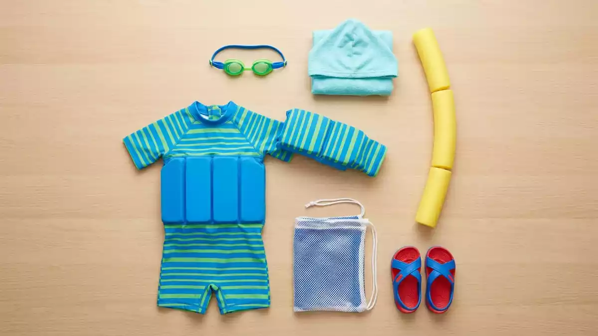 Flatlay-Arrangement rund um Kinder Schwimmanzug mit passenden Requisiten von oben