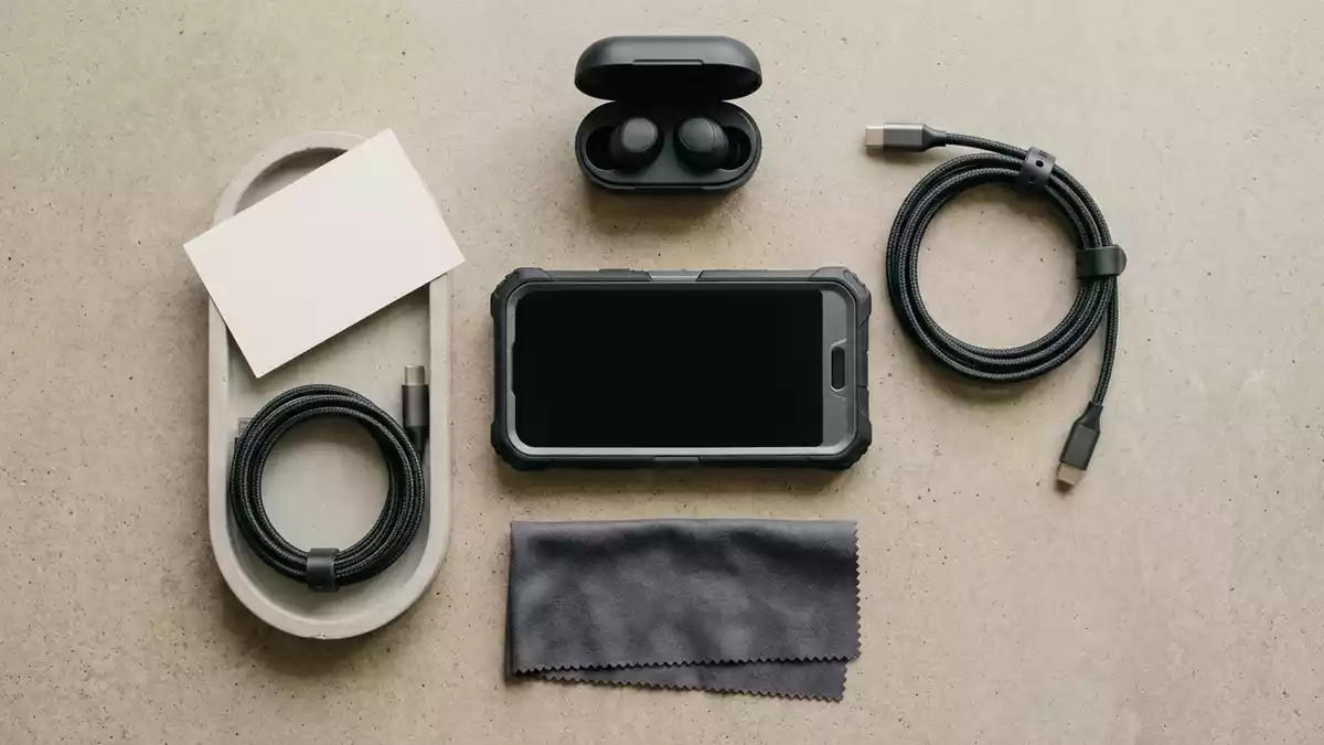 Flatlay-Arrangement rund um Smartphonehuelle mit passenden Requisiten von oben