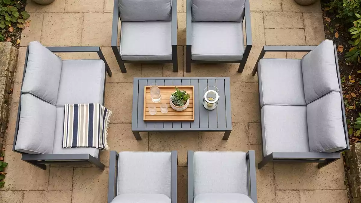 Flatlay-Arrangement rund um Gartenmoebelset mit passenden Requisiten von oben, neutral