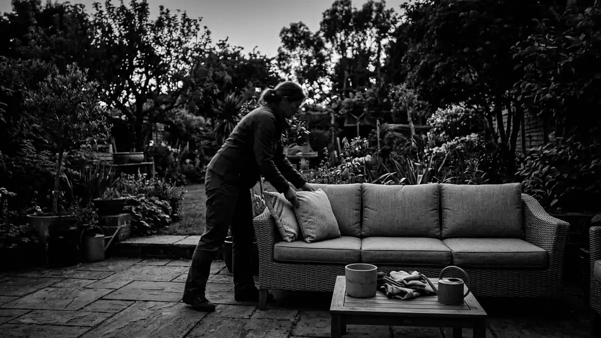 Schwarzweiss-Reportagebild mit Gartensofa in dokumentarischer Arbeitsumgebung, neutral