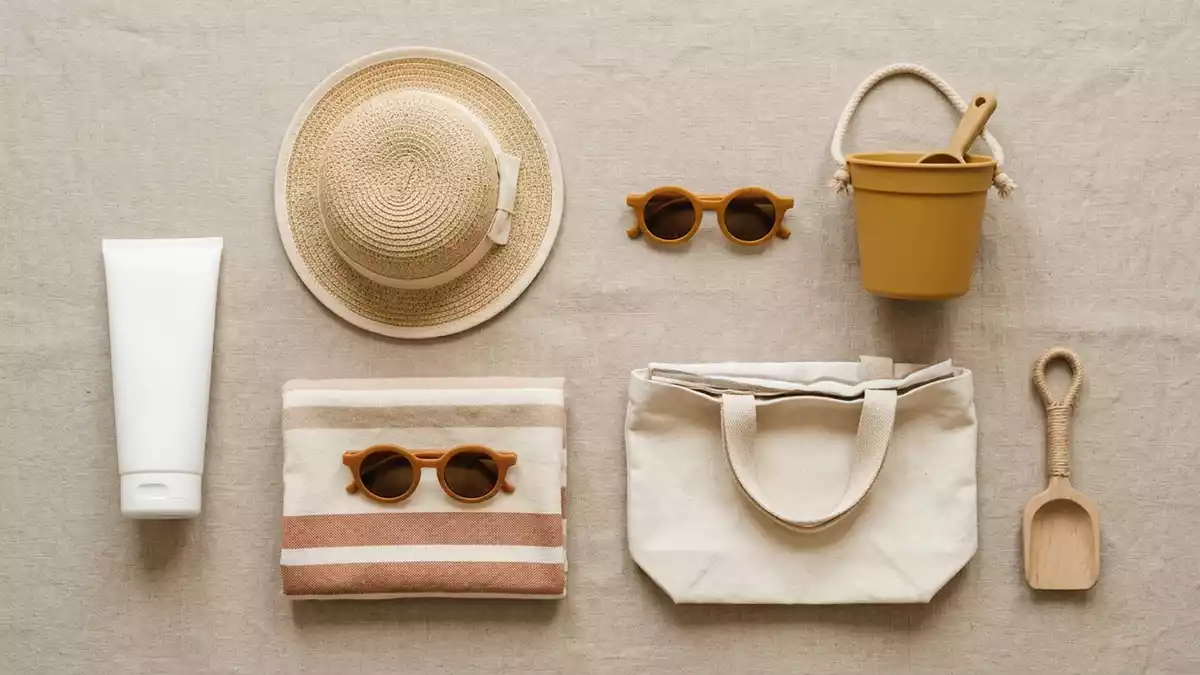 Flatlay-Arrangement rund um Kinder-Sonnencreme mit passenden Requisiten von oben