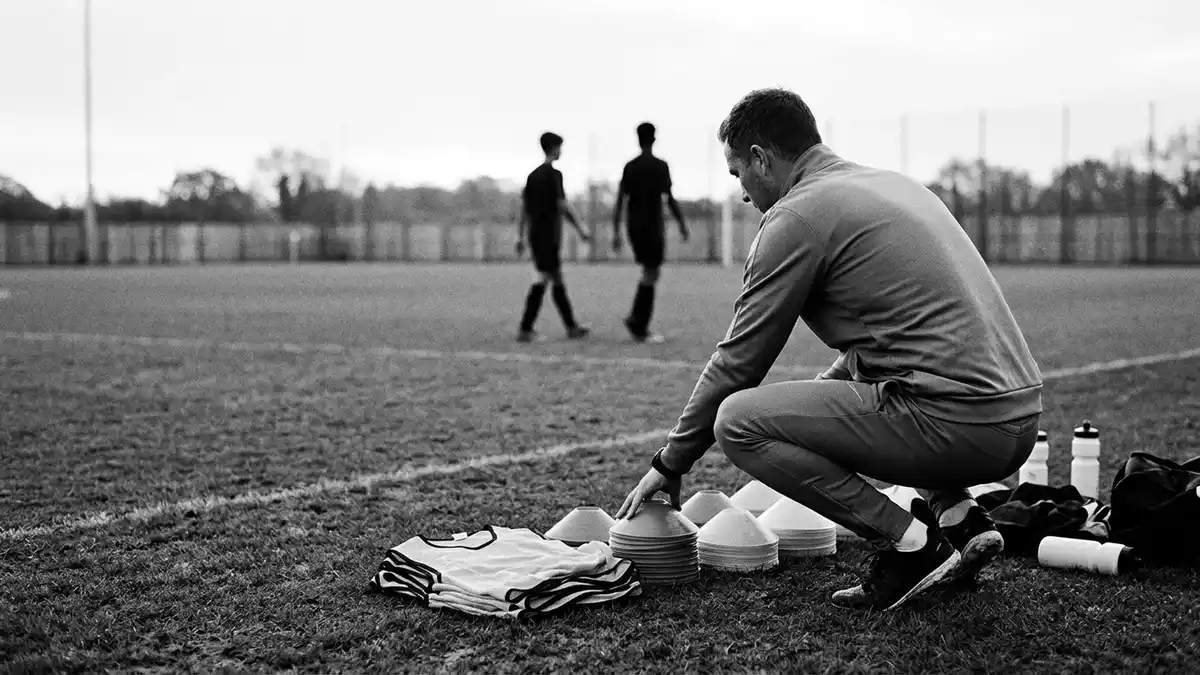 Schwarzweiss-Reportagebild mit Trainingsanzug in dokumentarischer Arbeitsumgebung