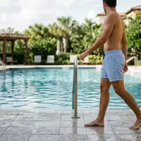 Fotorealistische Aufnahme von Badeshorts am Pool zum Thema Havaianas Herren Badeshorts Surf, natuerliches Licht - Foto: THN