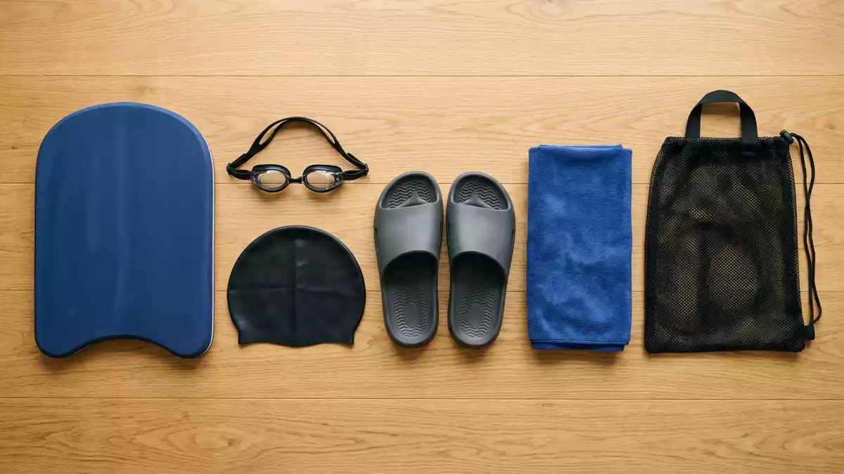 Flatlay-Arrangement rund um Schwimmbrett mit passenden Requisiten von oben, neutral