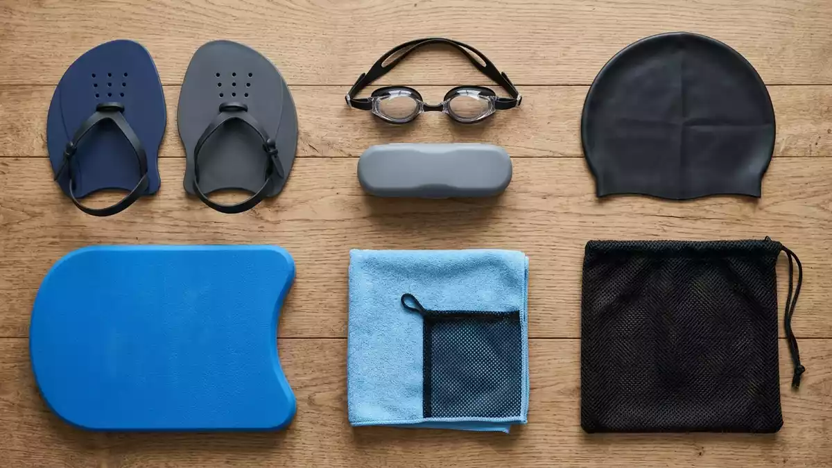 Flatlay-Arrangement rund um Schwimmpaddles mit passenden Requisiten von oben, neutral
