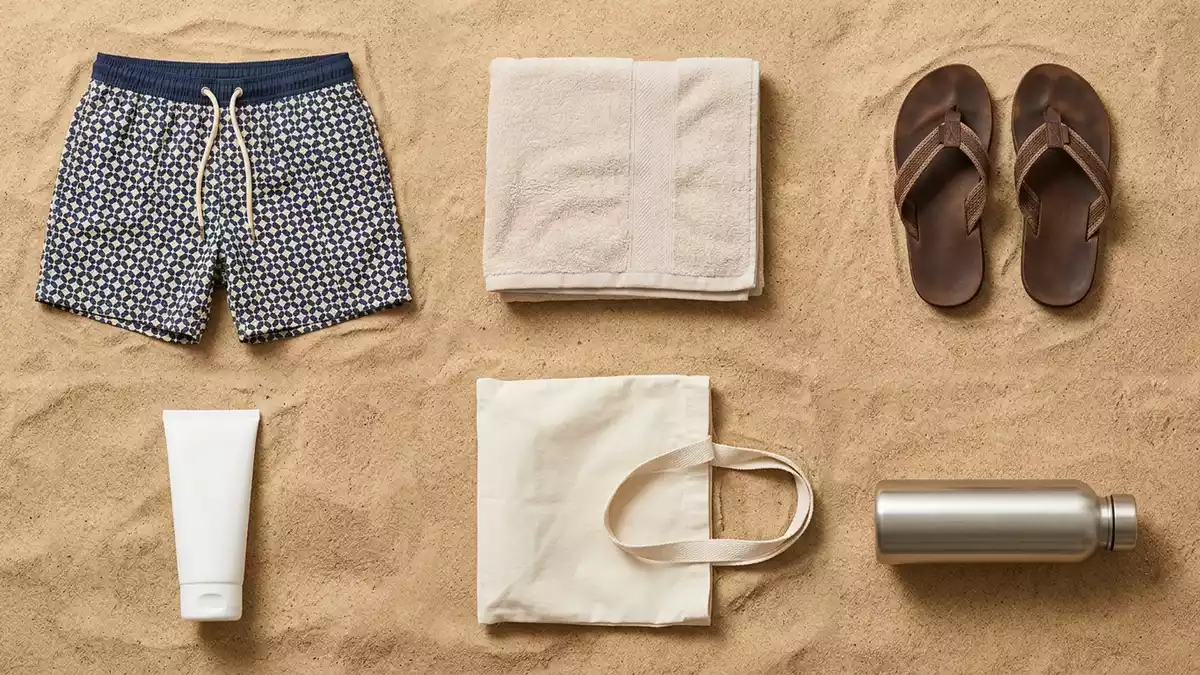 Flatlay-Arrangement rund um Badeshorts mit passenden Requisiten von oben, neutral