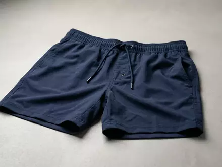 Fotorealistische Studioaufnahme von Herrenbadeshorts zum Thema Guess Herren Badeshorts Logo, klare Lichtfuehrung - Foto: THN