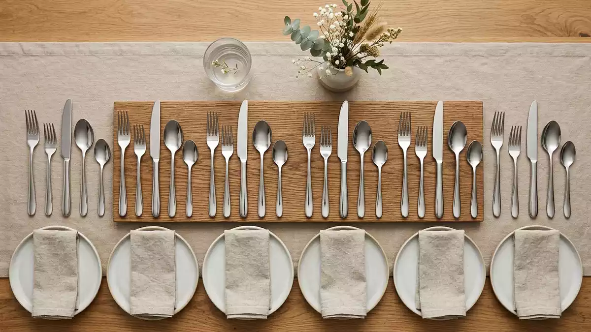 Flatlay-Arrangement rund um Besteckset mit passenden Requisiten von oben, neutral