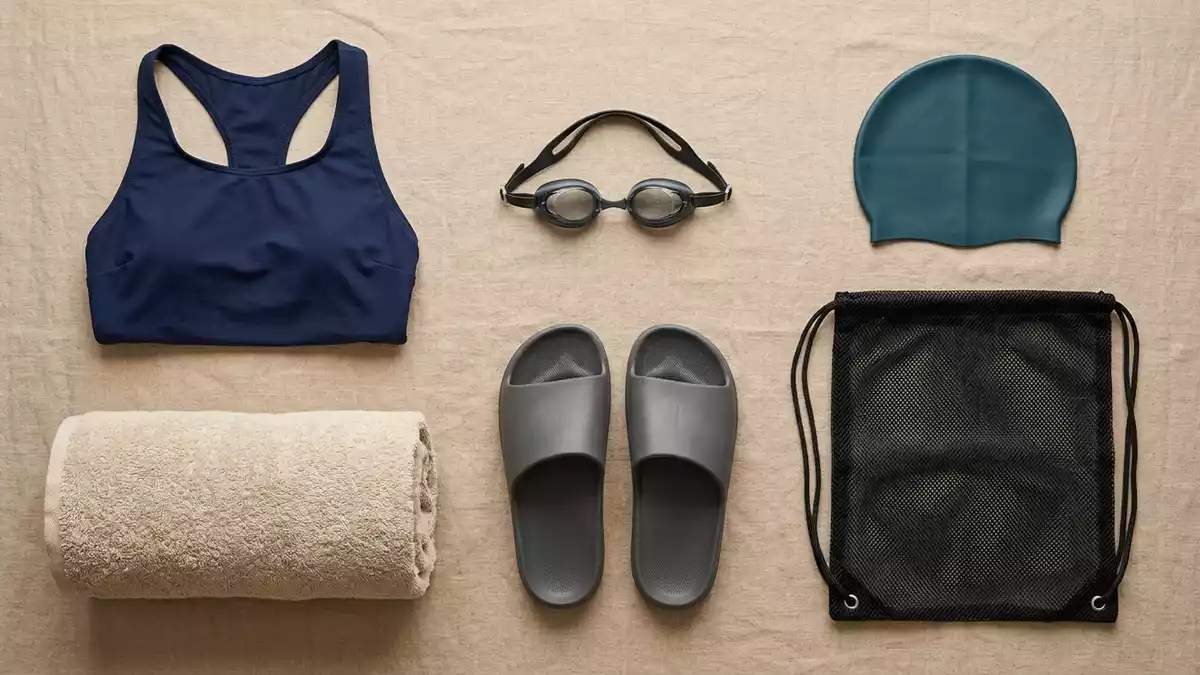 Flatlay-Arrangement rund um Badeanzug mit passenden Requisiten von oben, neutral