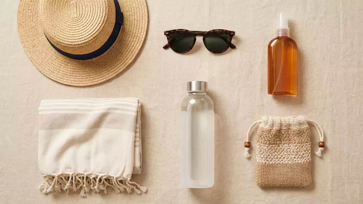 Flatlay-Arrangement rund um Sonnenschutzspray mit passenden Requisiten von oben