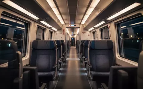 Innenansicht eines modernen ICE-Zugwaggons bei Nacht mit leeren Sitzreihen und atmosphärischer Beleuchtung. - Foto: über boerse-global.de