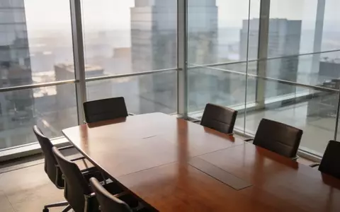 Ein minimalistischer, moderner Konferenzraum mit poliertem Holztisch und hellem Tageslicht in einem Bürogebäude. - Foto: über boerse-global.de