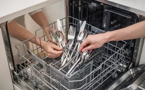 Hände beim ordnungsgemäßen Einräumen von Besteck in eine Geschirrspülmaschine in einer modernen Küche. - Foto: über boerse-global.de