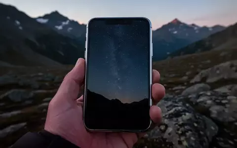 Ein modernes Smartphone in einer abgelegenen Berglandschaft bei Dämmerung, das auf eine Satellitenverbindung hindeutet. - Foto: über boerse-global.de
