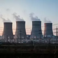 Ein modernes Gaskraftwerk mit Kühltürmen und Stromleitungen bei Dämmerung. - Foto: über boerse-global.de