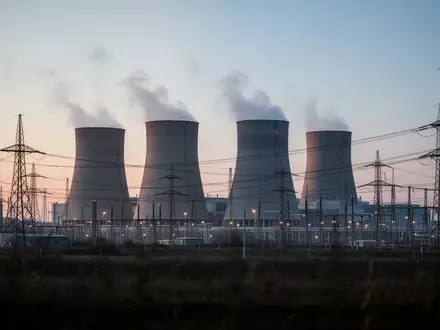 Ein modernes Gaskraftwerk mit Kühltürmen und Stromleitungen bei Dämmerung. - Foto: über boerse-global.de