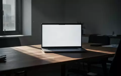 Ein minimalistischer Büroarbeitsplatz mit einem Laptop in einem dezent beleuchteten Raum. - Foto: über boerse-global.de