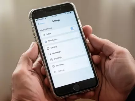 Nahaufnahme eines Smartphones in Händen, das ein Einstellungsmenü zur Leistungsoptimierung zeigt. - Foto: über boerse-global.de