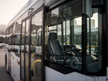 Ein moderner Stadtbus parkt in einem Depot bei Tageslicht, Fokus auf den leeren Fahrerplatz. - Foto: über boerse-global.de