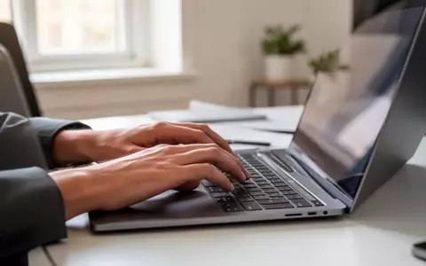 Nahaufnahme einer Person, die an einem modernen Laptop in einem hellen Büro arbeitet. - Foto: über boerse-global.de