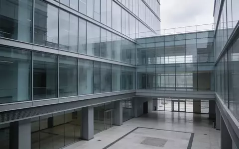 Moderne Glasfassade eines Bürogebäudes an einem trüben Tag. - Foto: über boerse-global.de