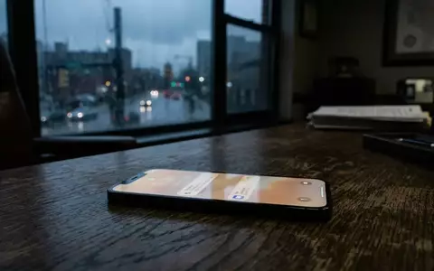 Ein Smartphone auf einem dunklen Schreibtisch in einem Regierungsbüro, das eine eingehende Benachrichtigung anzeigt. - Foto: über boerse-global.de