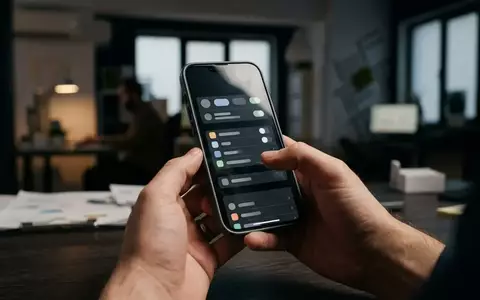 Nahaufnahme eines modernen Smartphones in den Händen einer Person in einer professionellen Büroumgebung. - Foto: über boerse-global.de