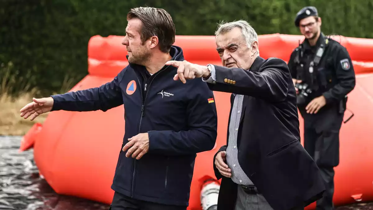Nordrhein-Westfalens Innenminister Herbert Reul lässt sich an der deutsch-belgischen Grenze an einer Wassertankstation die Lage erläutern.  - Bild: Oliver Berg/dpa