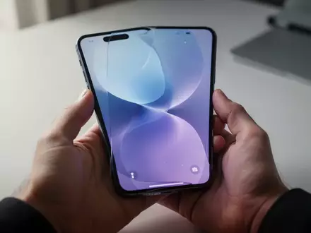 Ein modernes Smartphone in den Händen einer Person zeigt eine minimalistische Benutzeroberfläche bei natürlichem Licht. - Foto: über boerse-global.de