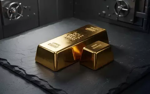 Ein glänzender Goldbarren auf einer dunklen Schieferoberfläche in einem Tresorraum mit dramatischer Beleuchtung. - Foto: über boerse-global.de