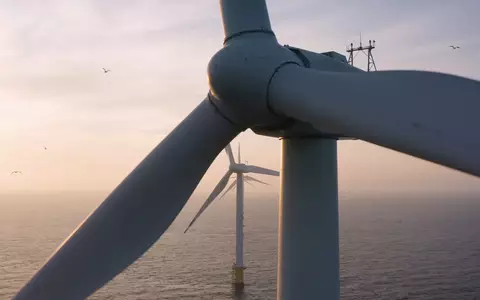 Moderne Windkraftanlagen in einem Offshore-Windpark bei Sonnenaufgang über dem Meer. - Foto: über boerse-global.de