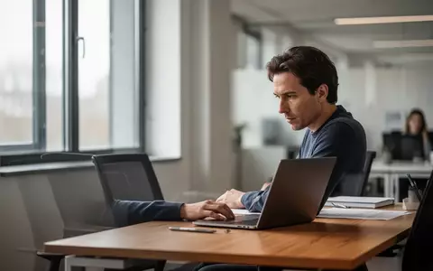 Ein konzentrierter Mitarbeiter in einem modernen Büro vor einem Laptop, der die Auswirkungen von Sozialversicherungsbeiträgen symbolisiert. - Foto: über boerse-global.de