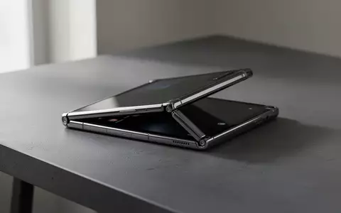 Ein hochwertiges faltbares Smartphone liegt halb geöffnet auf einem dunklen, minimalistischen Schreibtisch. - Foto: über boerse-global.de