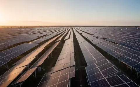 Weitläufiger Solarpark mit zahlreichen Photovoltaik-Modulen bei goldenem Sonnenlicht. - Foto: über boerse-global.de