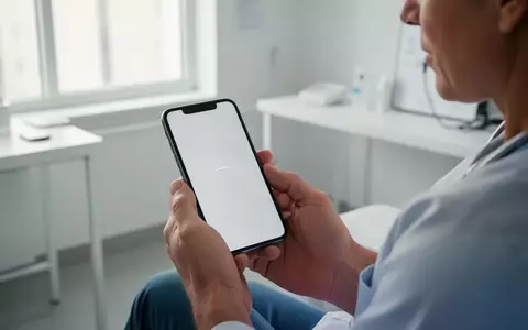 Eine Person hält in einer hellen, modernen medizinischen Umgebung ein Smartphone, während sie ihr Wohlbefinden digital dokumentiert. - Foto: über boerse-global.de