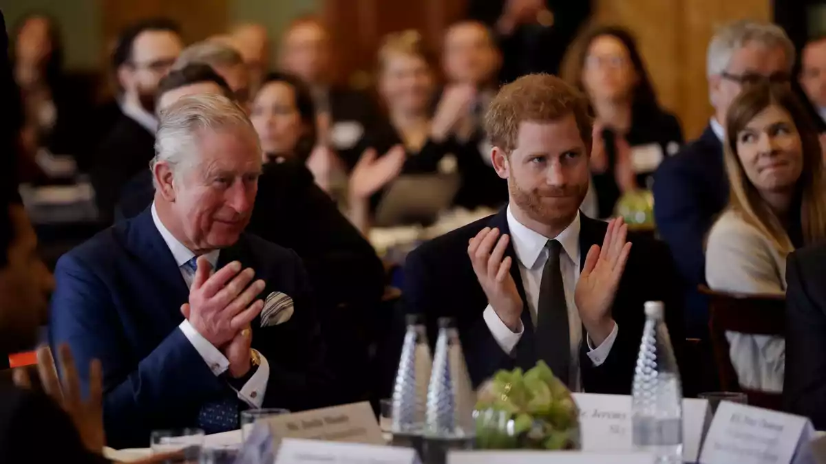 Ein Bild aus vergangenen Zeiten: Harry (r.) und sein Vater Charles, damals Prinz, an einem Tisch. (Archivbild) - Bild: Matt Dunham/AP POOL/dpa