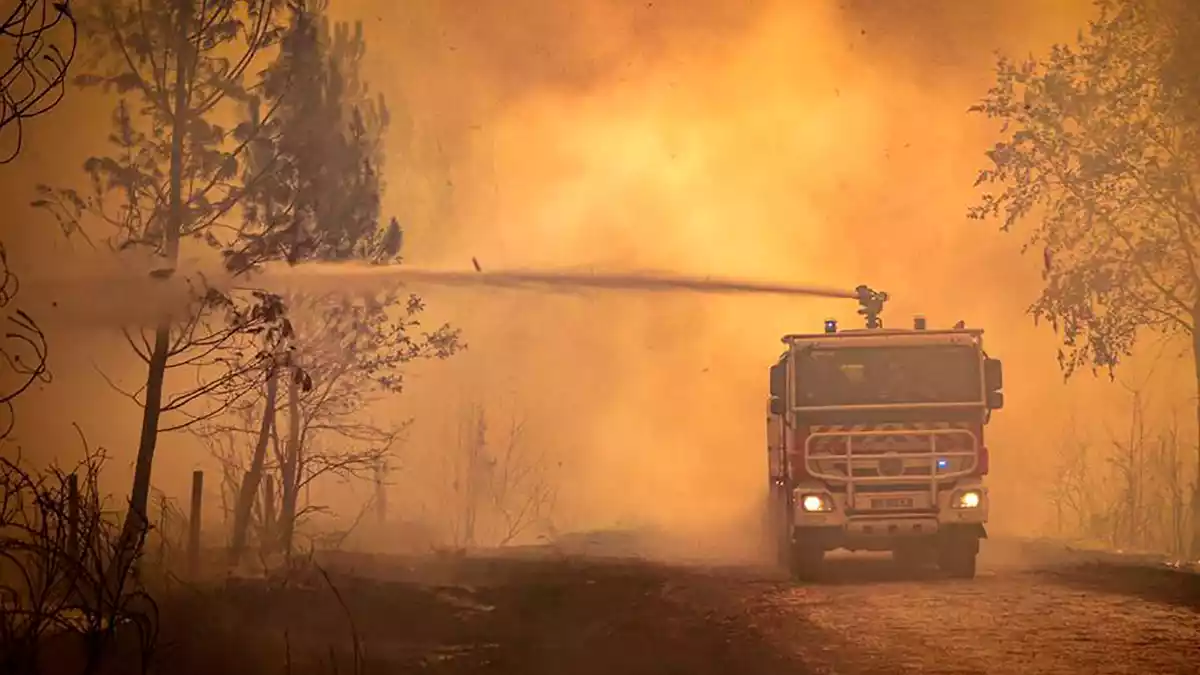 Ein Feuerwehrwagen sprüht Flüssigkeit auf einen Waldbrand in der Region Bordeaux. (Archivbild) - Bild: Uncredited/Service Communication-Protocole SDIS 33/AP/dpa