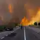 Dichter Rauch während eines Waldbrandes am Rande einer Landstraße in Spanien (Archivbild) - Bild: Paloma V. Escarpa/EUROPA PRESS/dpa
