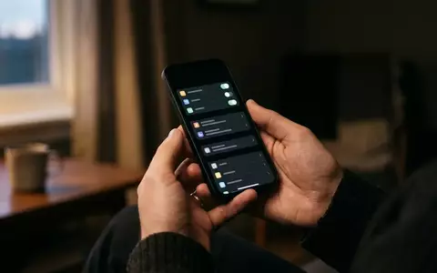 Nahaufnahme eines Smartphones mit aktiviertem Dark Mode in einer Hand, während Systemeinstellungen vorgenommen werden. - Foto: über boerse-global.de