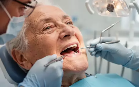 Nahaufnahme einer zahnärztlichen Untersuchung bei einem älteren Patienten in einer hellen Praxisumgebung. - Foto: über boerse-global.de
