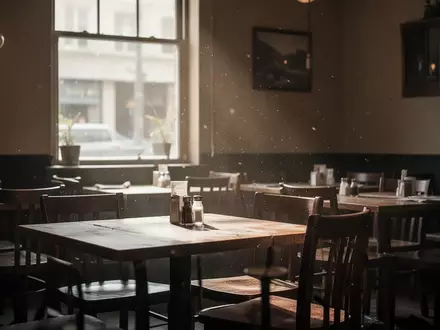 Ein leerer Gastraum in einem Restaurant mit gedimmtem Licht und unbesetzten Tischen bei Tageslicht. - Foto: über boerse-global.de