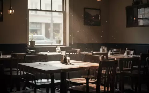 Ein leerer Gastraum in einem Restaurant mit gedimmtem Licht und unbesetzten Tischen bei Tageslicht. - Foto: über boerse-global.de