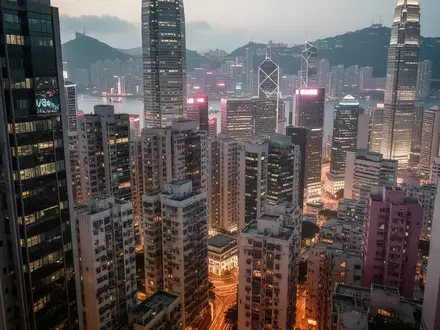 Blick auf die nächtliche Skyline von Hongkong mit dicht gedrängten Hochhäusern und leuchtenden Bürofenstern. - Foto: über boerse-global.de