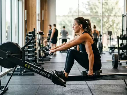 Eine Person trainiert in einem modernen Fitnessstudio mit Kraft- und Ausdauergeräten zur Verbesserung der Gesundheit. - Foto: über boerse-global.de