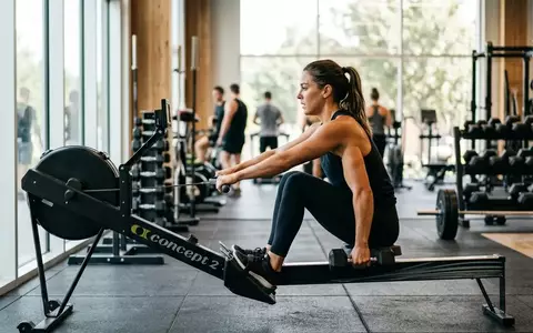 Eine Person trainiert in einem modernen Fitnessstudio mit Kraft- und Ausdauergeräten zur Verbesserung der Gesundheit. - Foto: über boerse-global.de