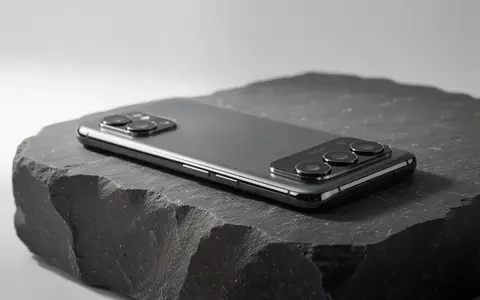 Ein minimalistisches Smartphone auf einer dunklen Steinoberfläche bei natürlichem Licht. - Foto: über boerse-global.de