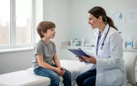 Ein Kinderarzt spricht in einer hellen, modernen Arztpraxis mit einem etwa zehnjährigen Kind bei einer Vorsorgeuntersuchung. - Foto: über boerse-global.de