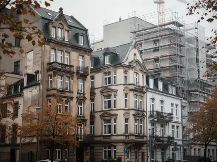 Ein älteres Wohnhaus in einem dicht bebauten Stadtviertel unter bewölktem Himmel. - Foto: über boerse-global.de