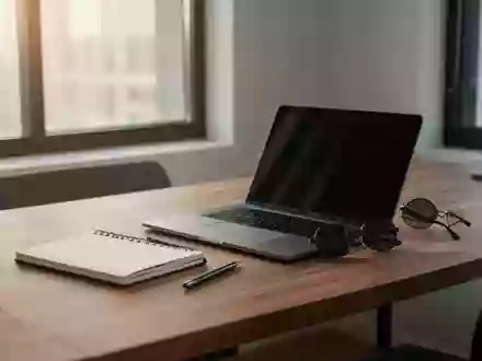Ein minimalistischer Schreibtisch mit Laptop und Sonnenbrille in natürlichem Tageslicht. - Foto: über boerse-global.de